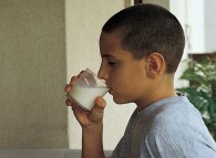 Bambino mentre beve un bicchiere di latte