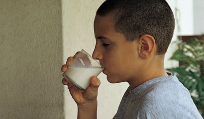 Bambino mentre beve un bicchiere di latte